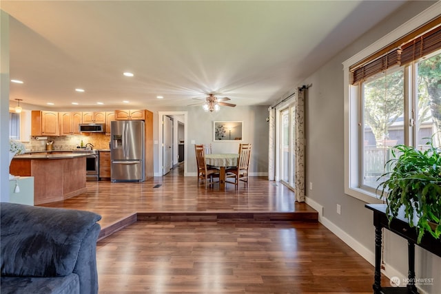 living room with recessed lighting, dark wood-style flooring, and baseboards