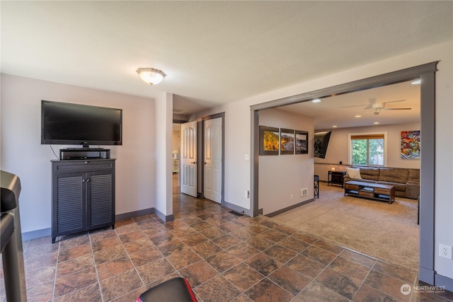 carpeted living area with recessed lighting, stone finish floor, and baseboards