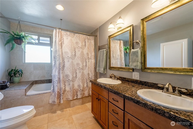 full bath with tiled shower / bath combo, a sink, toilet, and tile patterned floors