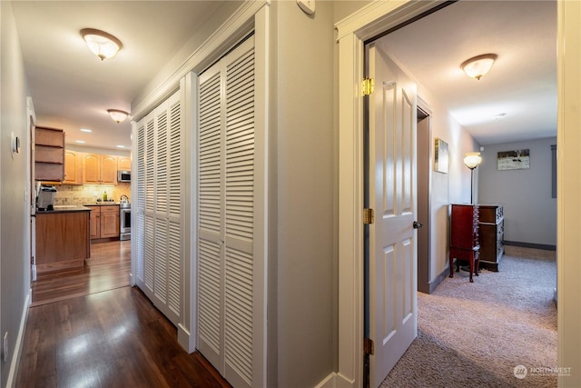 hall featuring dark wood-style floors and baseboards