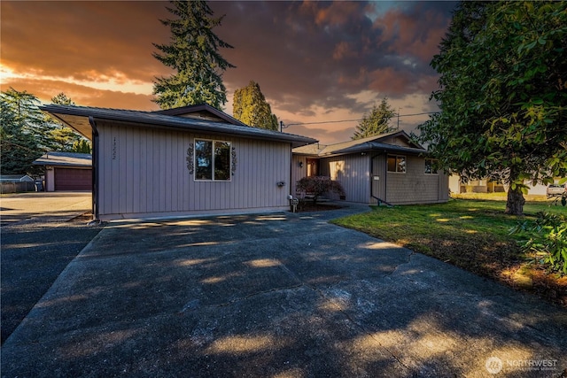 view of front of house with a yard and an outbuilding