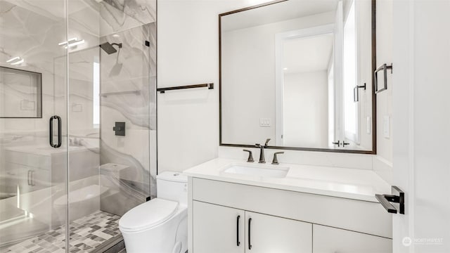 bathroom with vanity, toilet, and a shower with door