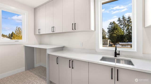 kitchen with sink, light tile patterned floors, and light stone counters