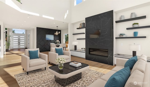 living room featuring a fireplace, a wealth of natural light, french doors, and light wood-type flooring