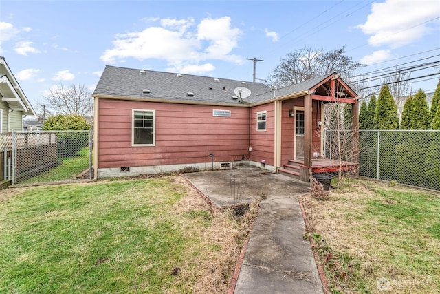 back of property with roof with shingles, a lawn, a patio area, and a fenced backyard