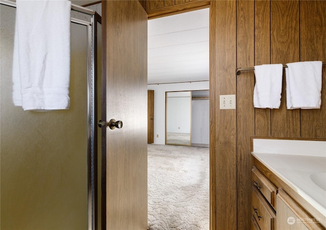 bathroom featuring vanity and a shower with door