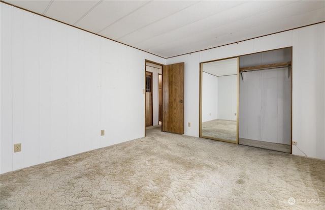 unfurnished bedroom with light carpet and a closet