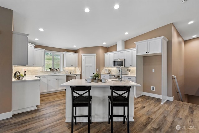 kitchen featuring a breakfast bar, sink, a kitchen island, stainless steel appliances, and white cabinets