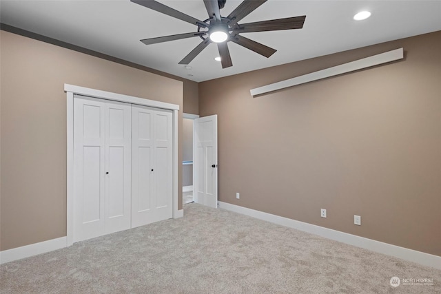 unfurnished bedroom with light colored carpet, ceiling fan, and a closet