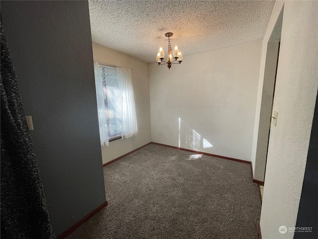 carpeted empty room with a notable chandelier and a textured ceiling