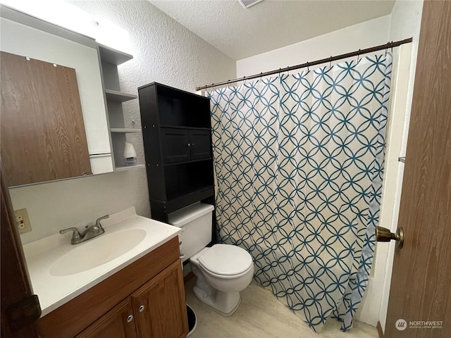 bathroom with vanity, toilet, a textured ceiling, and a shower with curtain