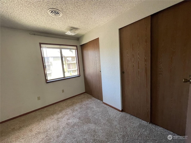 unfurnished bedroom featuring carpet flooring and a textured ceiling