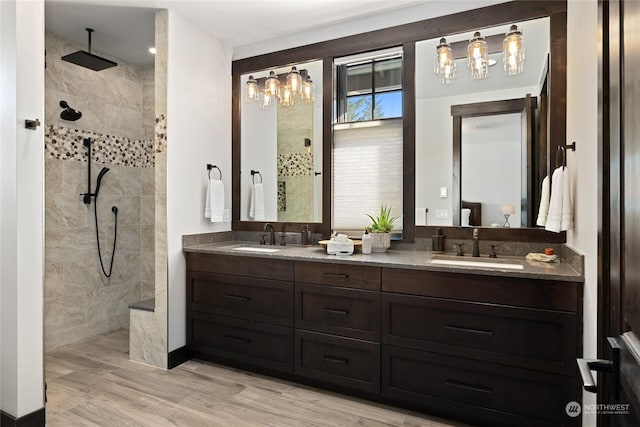 bathroom with vanity, hardwood / wood-style flooring, and a tile shower