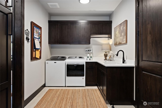 laundry area with separate washer and dryer, sink, and cabinets