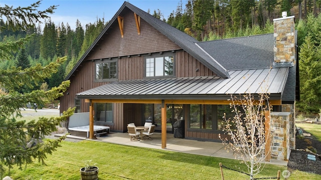 120 Rocky Run Loop, Cle Elum, WA 98922 - rear view of house featuring a standing seam roof, a patio, a lawn, a chimney, and a metal roof
