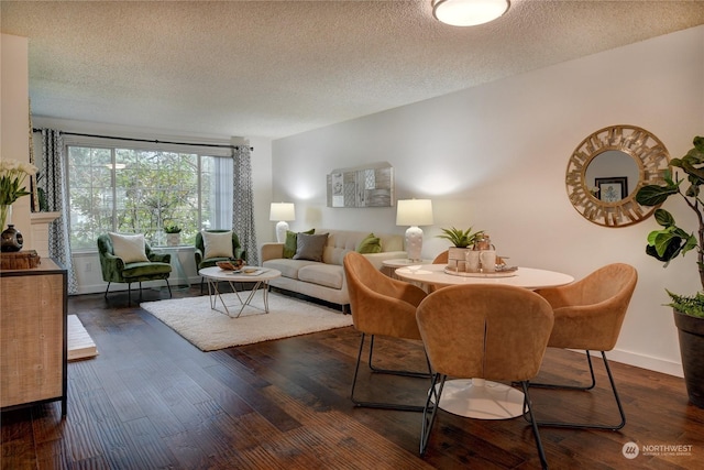 dining room with dark wood-type flooring and a textured ceiling