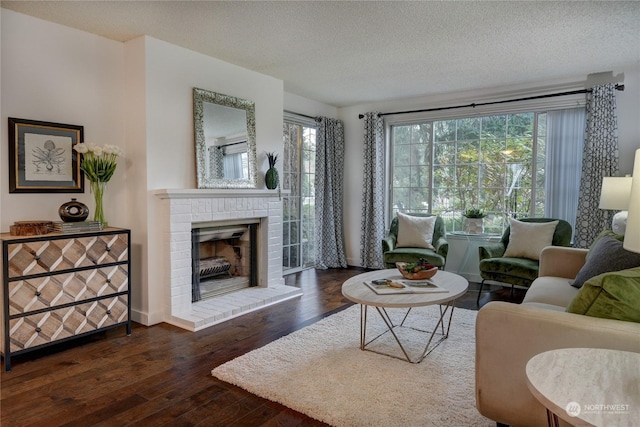 living room with a fireplace, dark wood-type flooring, and a textured ceiling