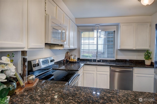 kitchen featuring white cabinetry, appliances with stainless steel finishes, sink, and dark stone countertops