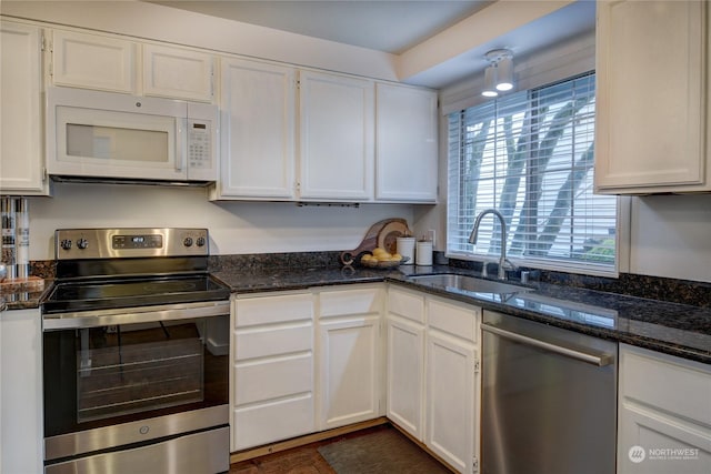 kitchen featuring dark stone countertops, appliances with stainless steel finishes, sink, and white cabinets