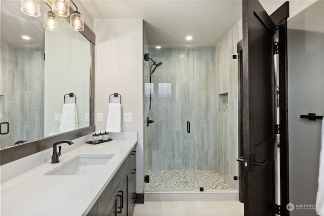 bathroom featuring vanity and a shower with door