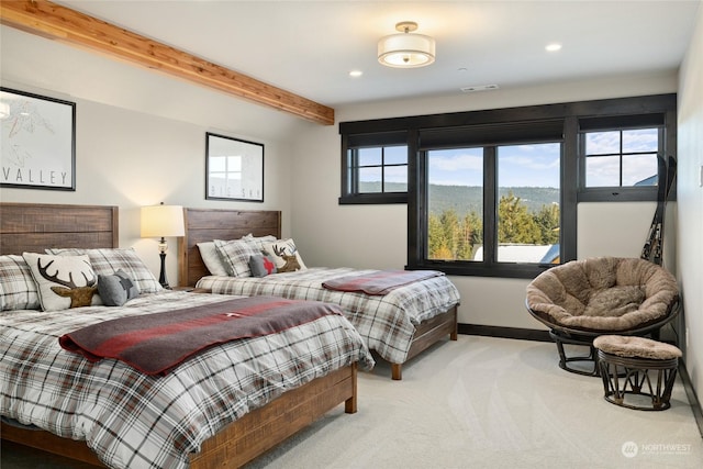 carpeted bedroom with multiple windows and beamed ceiling