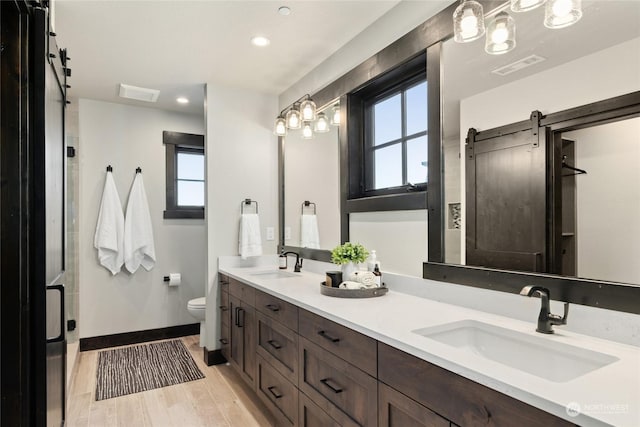 bathroom featuring hardwood / wood-style flooring, plenty of natural light, toilet, and vanity