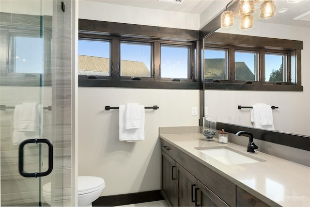 bathroom with vanity, an enclosed shower, plenty of natural light, and toilet