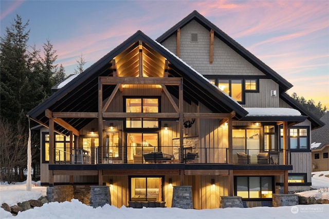 snow covered house featuring a balcony