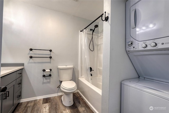 full bathroom featuring stacked washer / dryer, wood-type flooring, vanity, toilet, and shower / bath combo