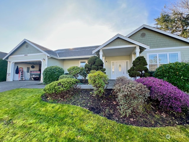 view of front of property featuring aphalt driveway, a front yard, and an attached garage