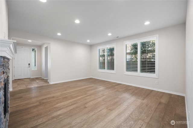 unfurnished room with a fireplace and light hardwood / wood-style floors