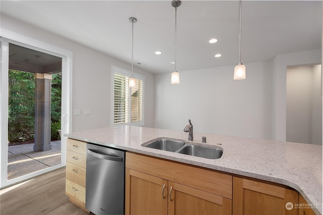 kitchen with light stone counters, stainless steel dishwasher, sink, and hanging light fixtures