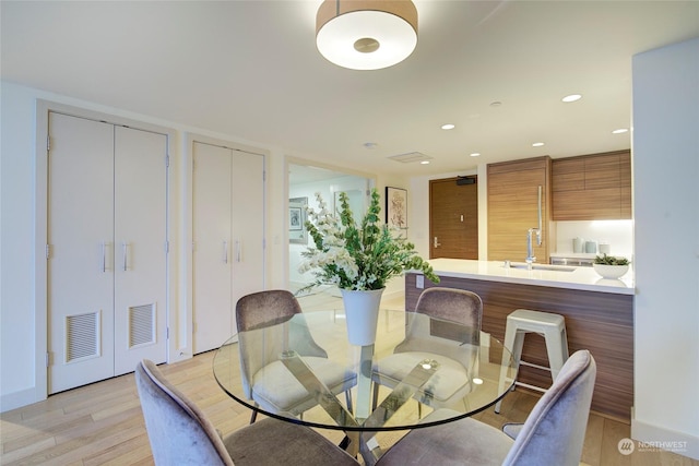 dining space featuring sink and light hardwood / wood-style floors