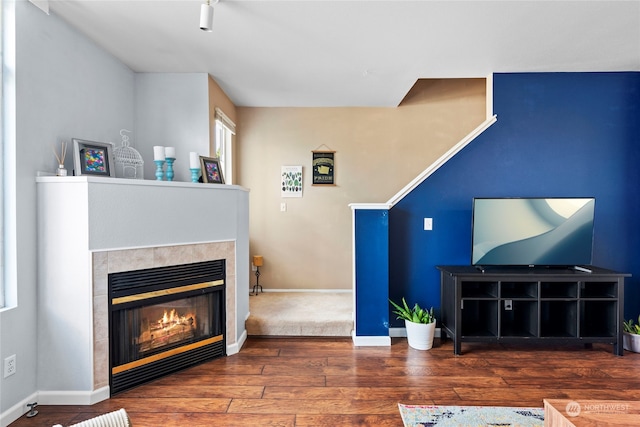 living room with dark wood-type flooring and a fireplace