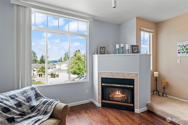 sitting room with dark hardwood / wood-style flooring and a tile fireplace