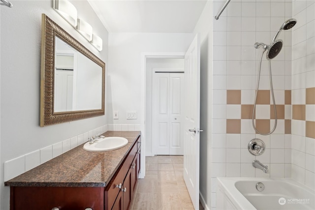 bathroom with tiled shower / bath, vanity, and tile patterned floors