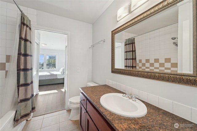 full bathroom with tile patterned flooring, vanity, shower / bath combo with shower curtain, and toilet