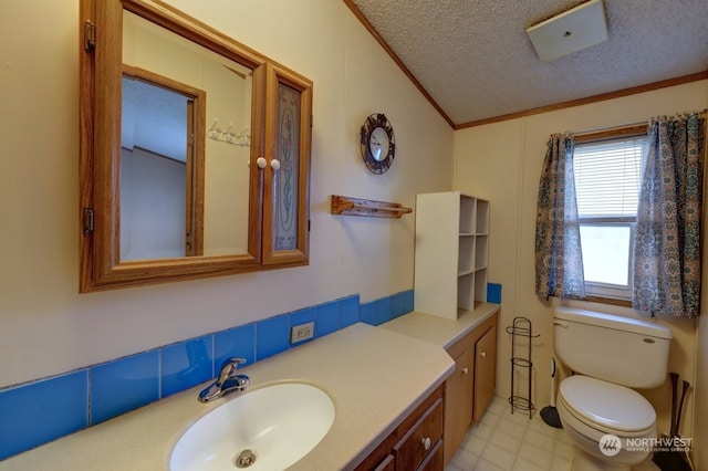 bathroom featuring vanity, ornamental molding, a textured ceiling, and toilet