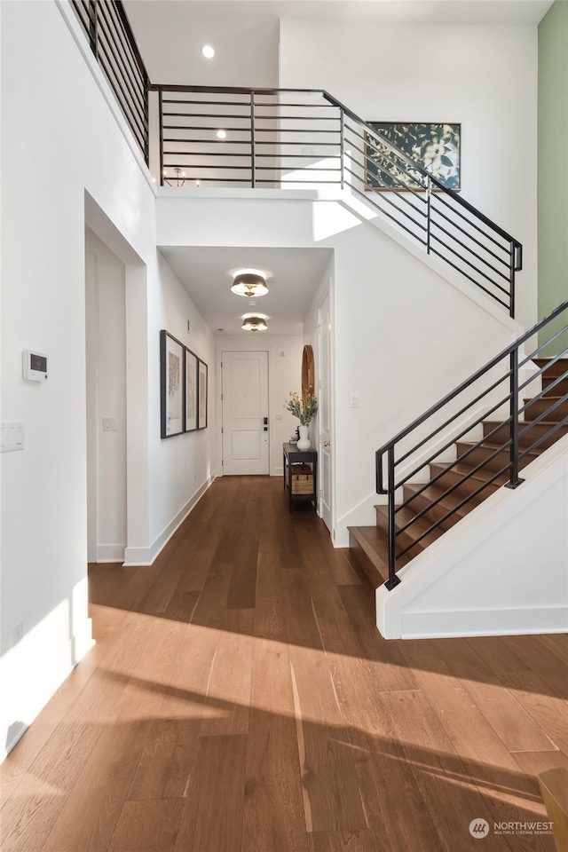 entrance foyer featuring a towering ceiling and hardwood / wood-style floors