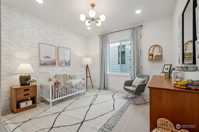 bedroom featuring a nursery area and a chandelier