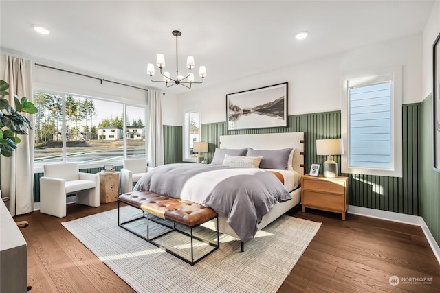 bedroom featuring wood-type flooring and an inviting chandelier