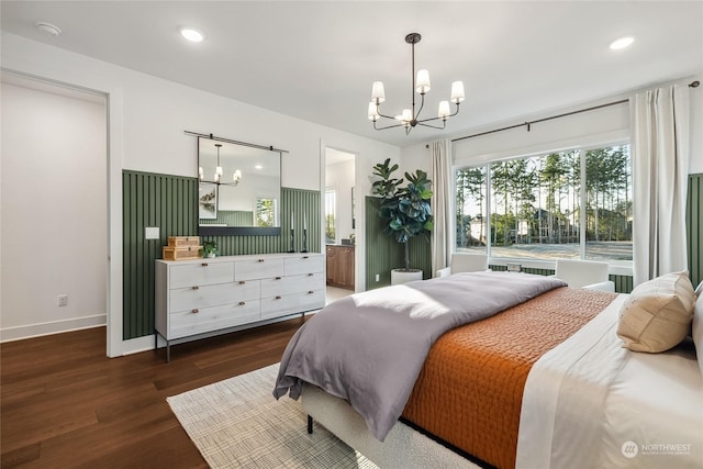 bedroom featuring dark wood-type flooring, a chandelier, and ensuite bath