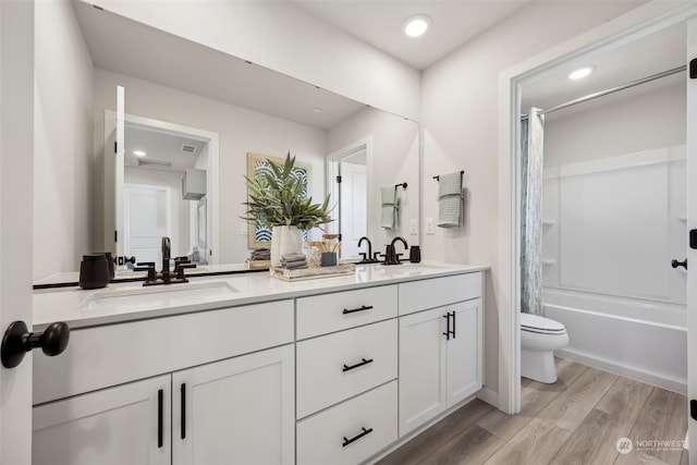 full bathroom featuring hardwood / wood-style flooring, vanity, toilet, and shower / bath combo with shower curtain