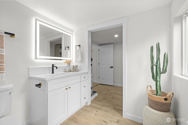 bathroom featuring vanity, hardwood / wood-style floors, and toilet