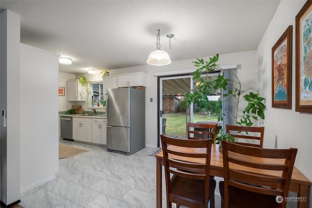 dining space with sink and a textured ceiling