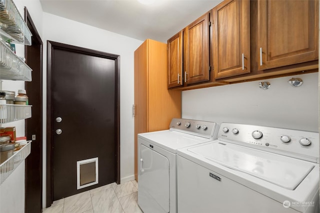 washroom with cabinets and washing machine and clothes dryer