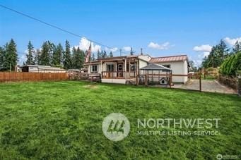 rear view of property with a gazebo and a lawn