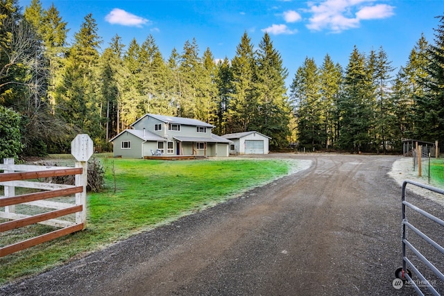 view of front of home with a garage, an outdoor structure, and a front yard