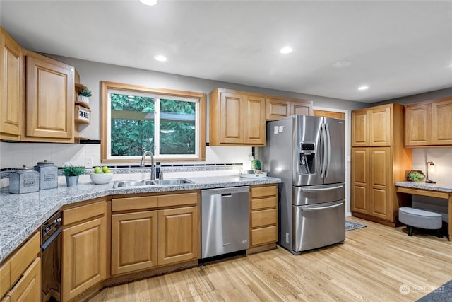 kitchen featuring sink, decorative backsplash, light hardwood / wood-style flooring, and appliances with stainless steel finishes