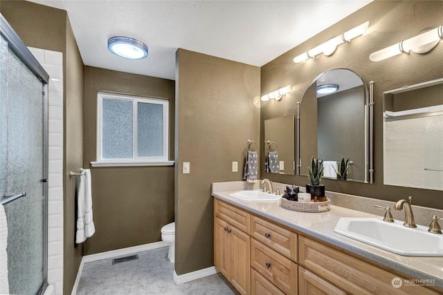 bathroom with vanity, a shower with shower door, and toilet